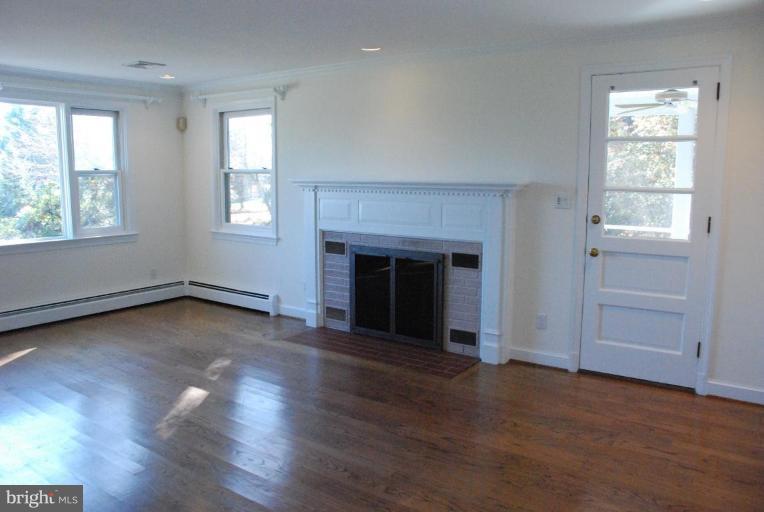 15500 Tierra Drive Silver Spring, MD 20906 - Photo 14 of 21 an empty room with wooden floor fireplace and windows