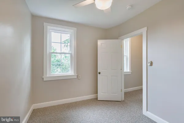 a bathroom with a granite countertop toilet a sink and a mirror