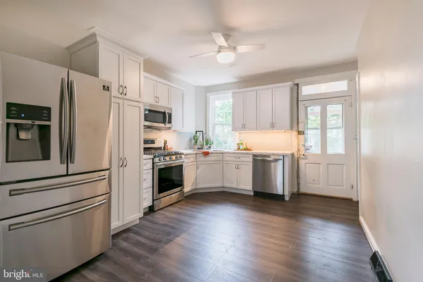 a kitchen with a refrigerator and a stove top oven