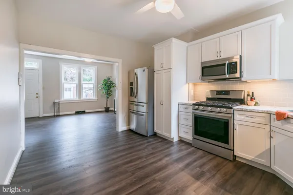 a kitchen with a refrigerator stove and wooden cabinets