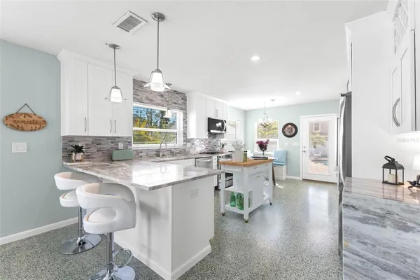 a kitchen with a sink a table and chairs in it