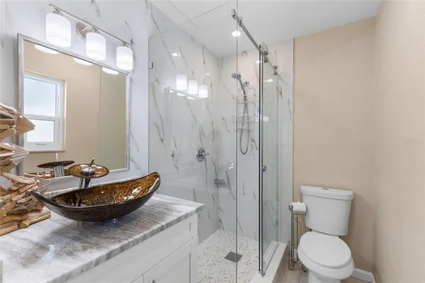 a bathroom with a granite countertop sink toilet and shower