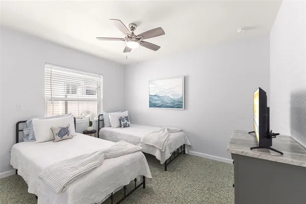 a bedroom with two beds and painting on the wall