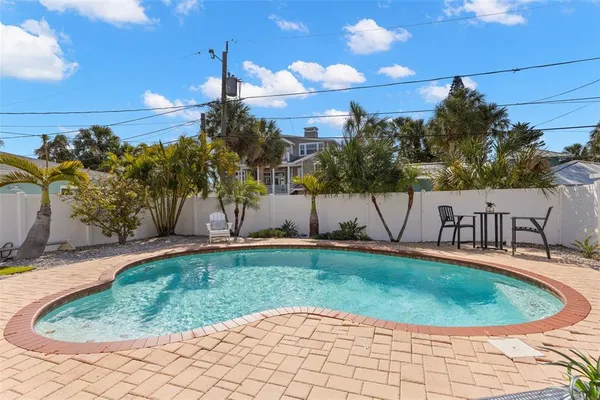 a view of a swimming pool with a yard and sitting area