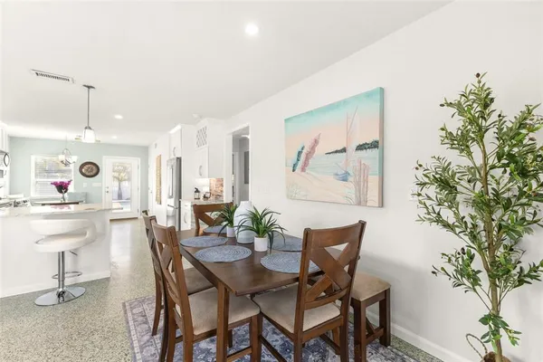 a dining room with furniture and a potted plant