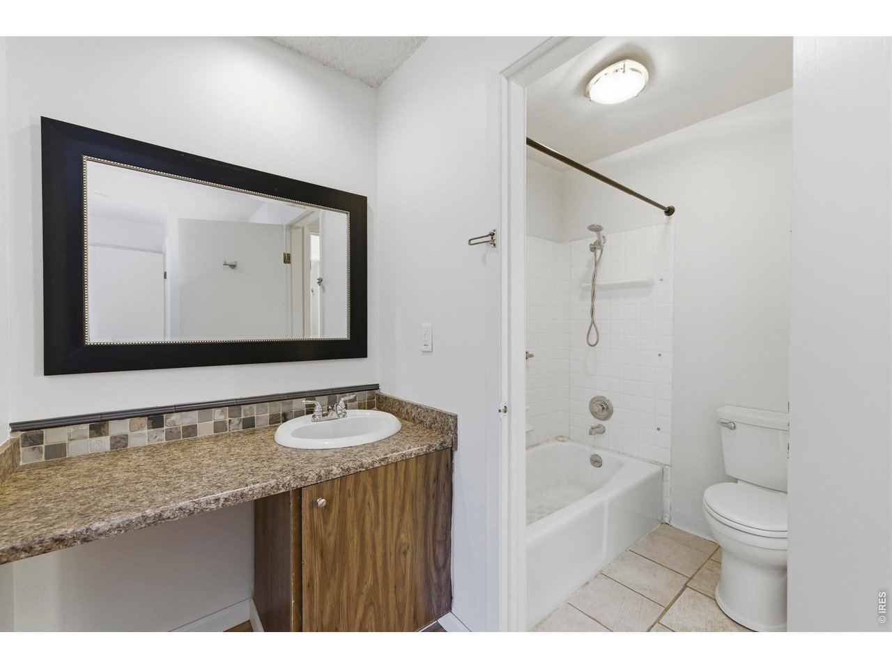 925 Columbia Road, Unit 824 Fort Collins, CO 80525 - Photo 15 of 36 a bathroom with a granite countertop sink mirror toilet and bathtub