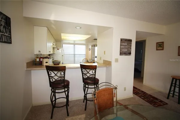 a kitchen with stainless steel appliances granite countertop a sink a stove a refrigerator a washer dryer and white cabinets