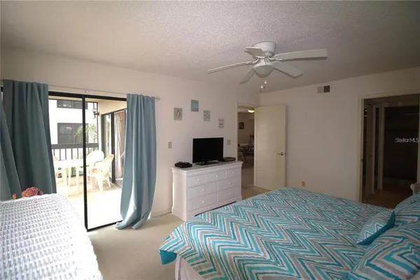 a spacious bedroom with a bed and a chandelier