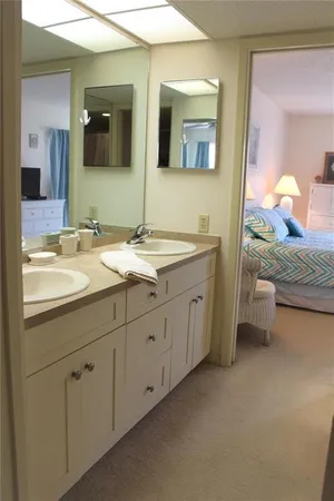 a bedroom with a bed chairs and a chandelier