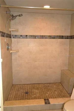 a bathroom with a granite countertop sink a toilet and shower