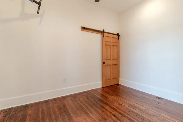 an empty room with wooden floor and wooden door