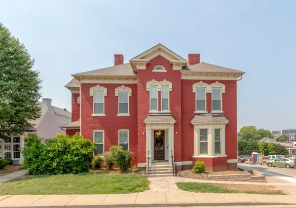 front view of a brick house with a yard