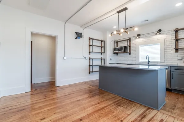 a kitchen with kitchen island stainless steel appliances a sink and a refrigerator