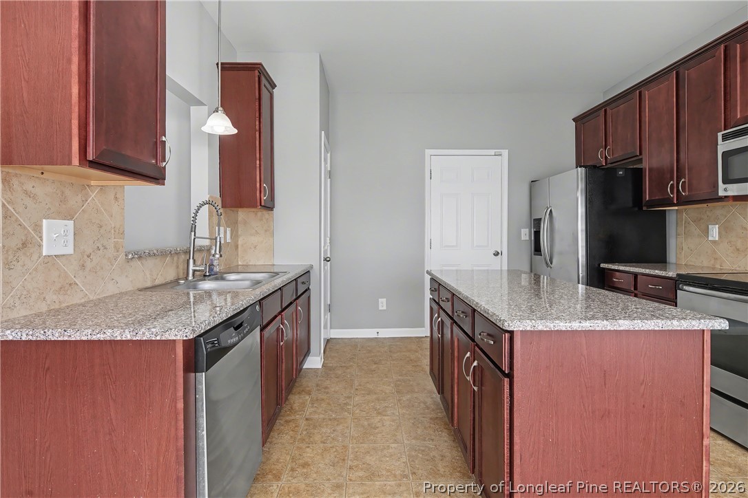 61 Bicentennial Way Cameron, NC 28326 - Photo 21 of 49 a kitchen with granite countertop stainless steel appliances a sink stove and cabinets