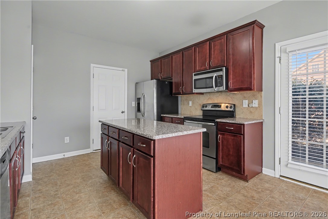 61 Bicentennial Way Cameron, NC 28326 - Photo 22 of 49 a kitchen with stainless steel appliances granite countertop a stove top oven microwave and refrigerator