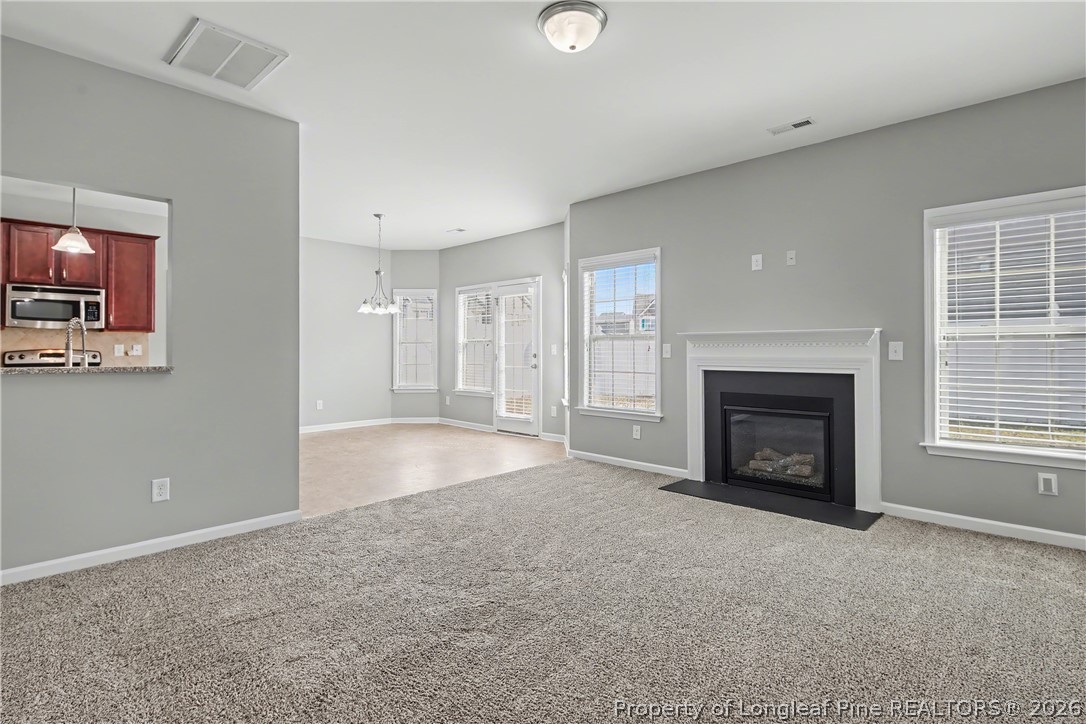 61 Bicentennial Way Cameron, NC 28326 - Photo 8 of 49 an empty room with windows fireplace and windows