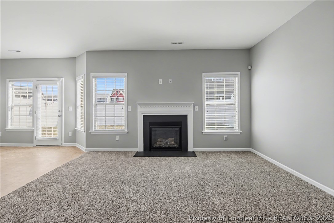 61 Bicentennial Way Cameron, NC 28326 - Photo 9 of 49 an empty room with windows and fireplace