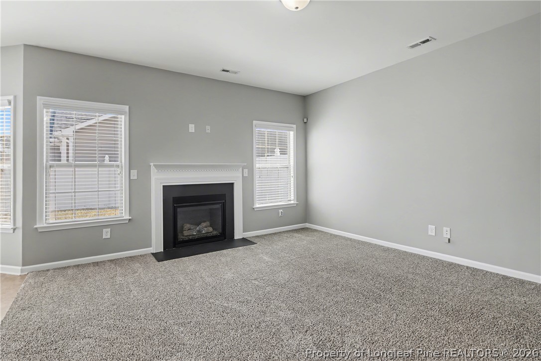 61 Bicentennial Way Cameron, NC 28326 - Photo 10 of 49 a view of an empty room with a window and fireplace