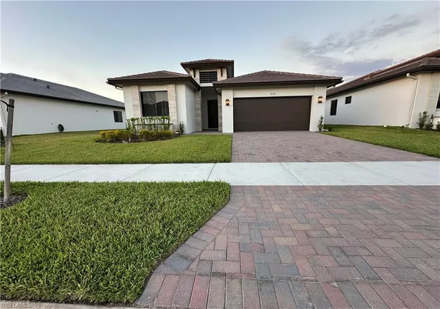 a front view of a house with a yard and garage