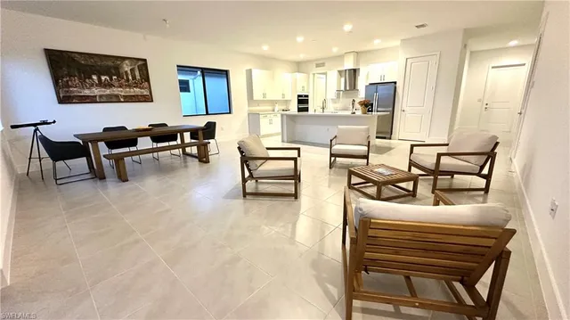 a living room with furniture and a dining table with kitchen view