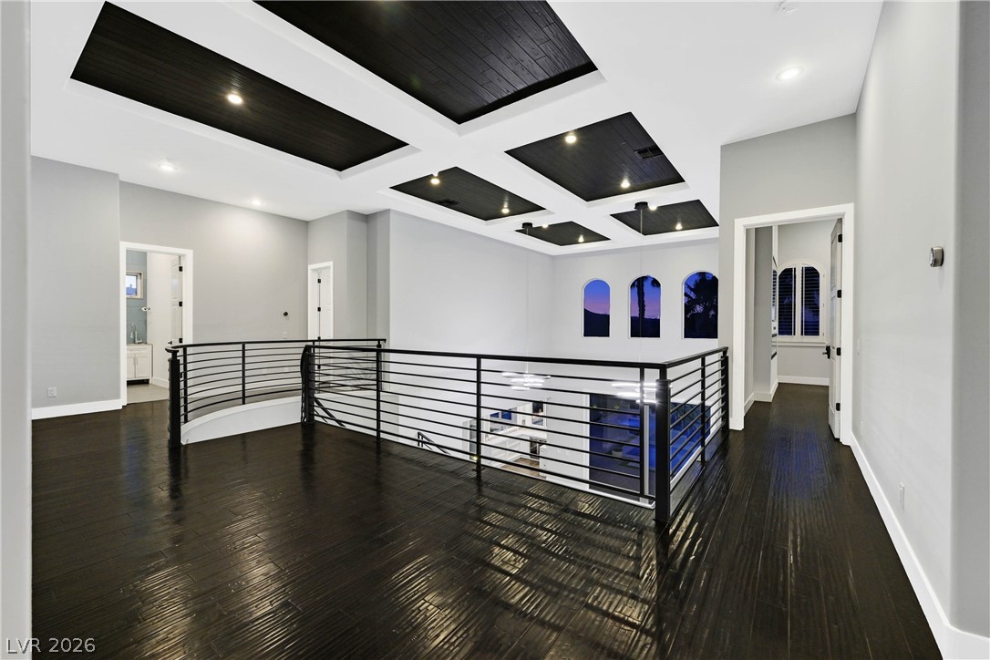 6 Rue Du Ville Henderson, NV 89011 - Photo 55 of 99 This spacious loft area features an elegant coffered ceiling and dark hardwood flooring, offering a sophisticated living space.