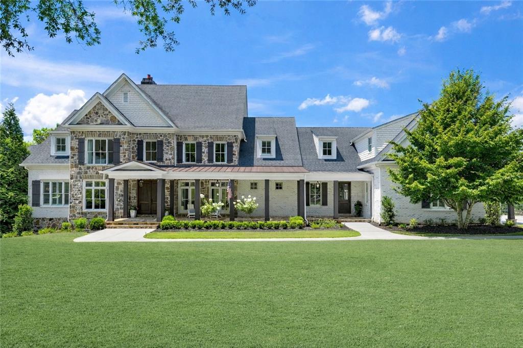 a front view of a house with lots of trees and plants