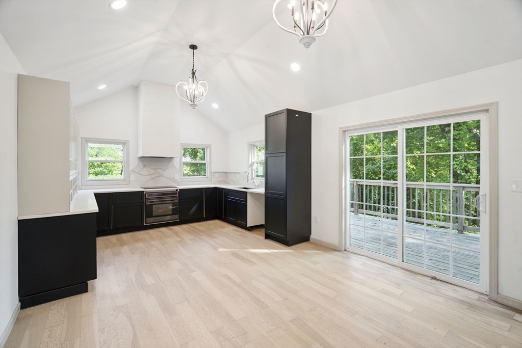 18 Chestnut Hill Road Millville, MA 01529 - Photo 5 of 26 a large kitchen with stainless steel appliances a large counter top a refrigerator and a chandelier