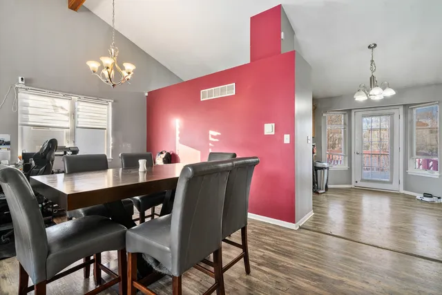 a dining room with furniture a chandelier and wooden floor