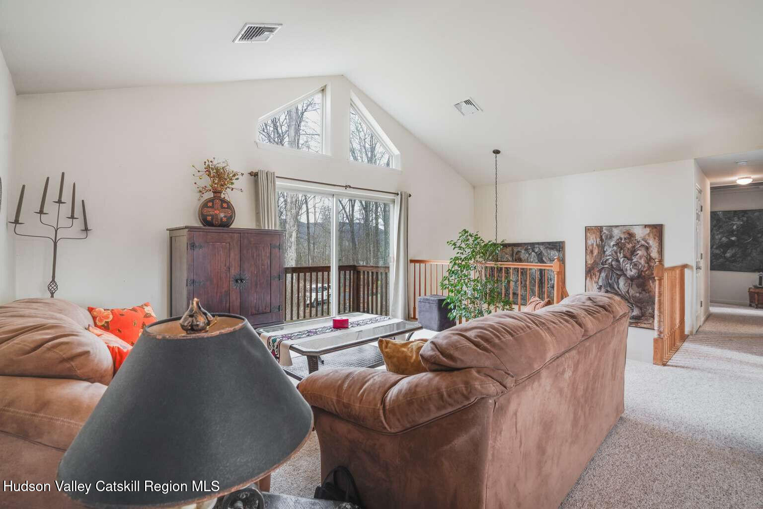 257 Bruynswick Road New Paltz, NY 12561 - Photo 3 of 23 a living room with furniture a large window and a chandelier