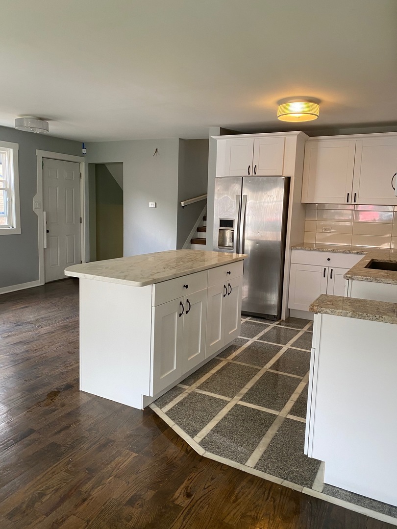 6732 South Peoria Street Chicago, IL 60621 - Photo 4 of 16 a kitchen with kitchen island a counter top space a sink appliances and cabinets
