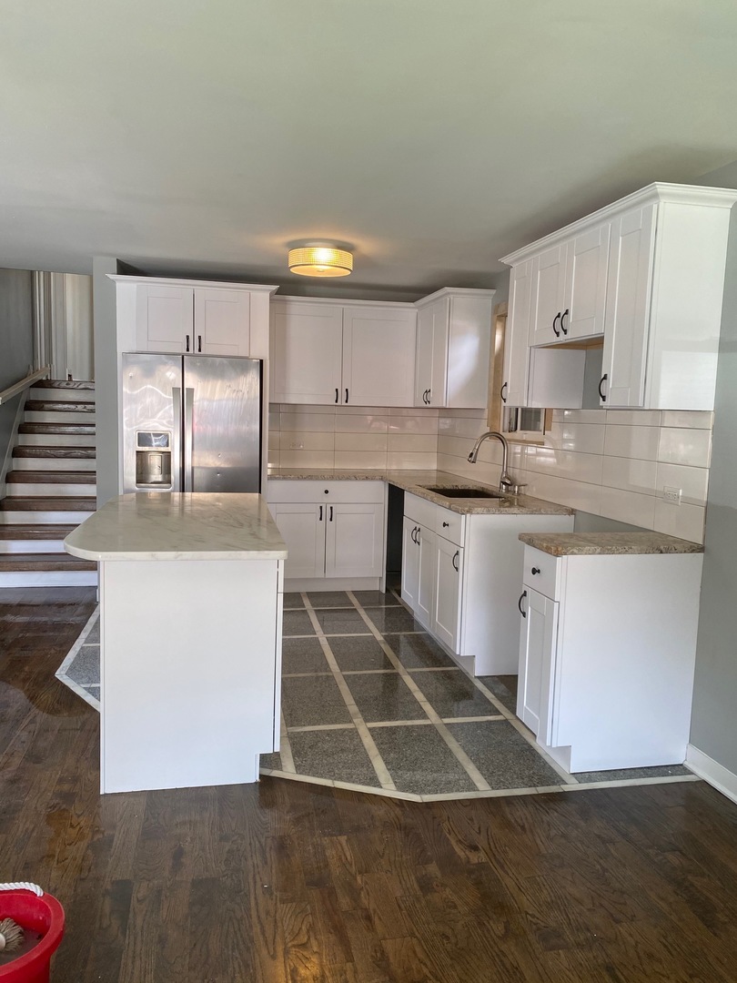 6732 South Peoria Street Chicago, IL 60621 - Photo 5 of 16 a kitchen with stainless steel appliances granite countertop a sink a stove a refrigerator and white cabinets