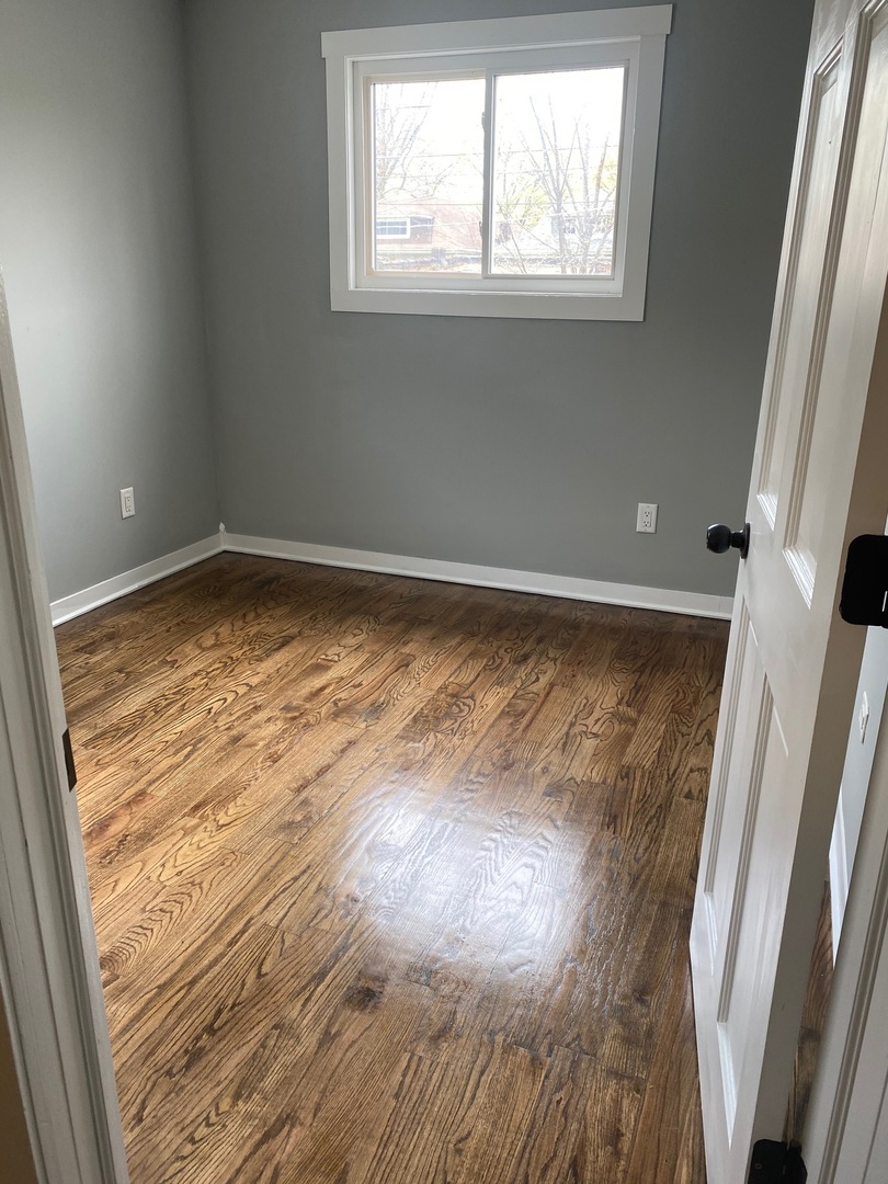 6732 South Peoria Street Chicago, IL 60621 - Photo 9 of 16 a view of a room with wooden floor and window