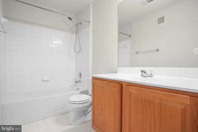 a bathroom with a bathtub shower sink mirror and toilet