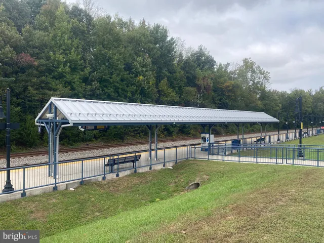 a view of a white house with a big yard and sitting area