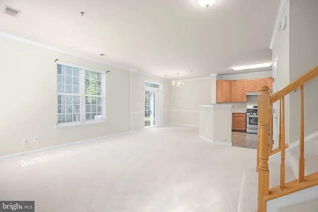 a view of an empty room with a kitchen