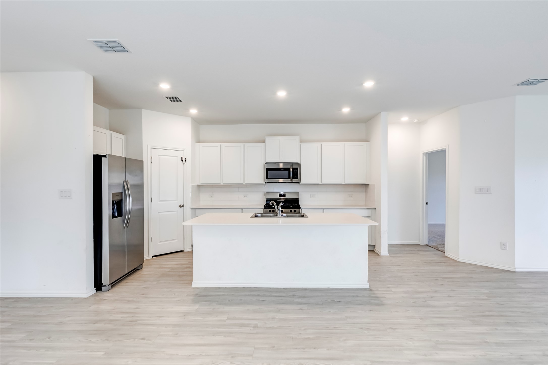 591 Avre Loop Kyle, TX 78640 - Photo 11 of 34 a view of kitchen with stainless steel appliances kitchen island a stove a refrigerator a oven and a sink