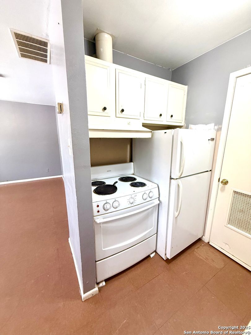643 West Summit, Unit 2 San Antonio, TX 78212 - Photo 8 of 12 a kitchen with white cabinets and white appliances