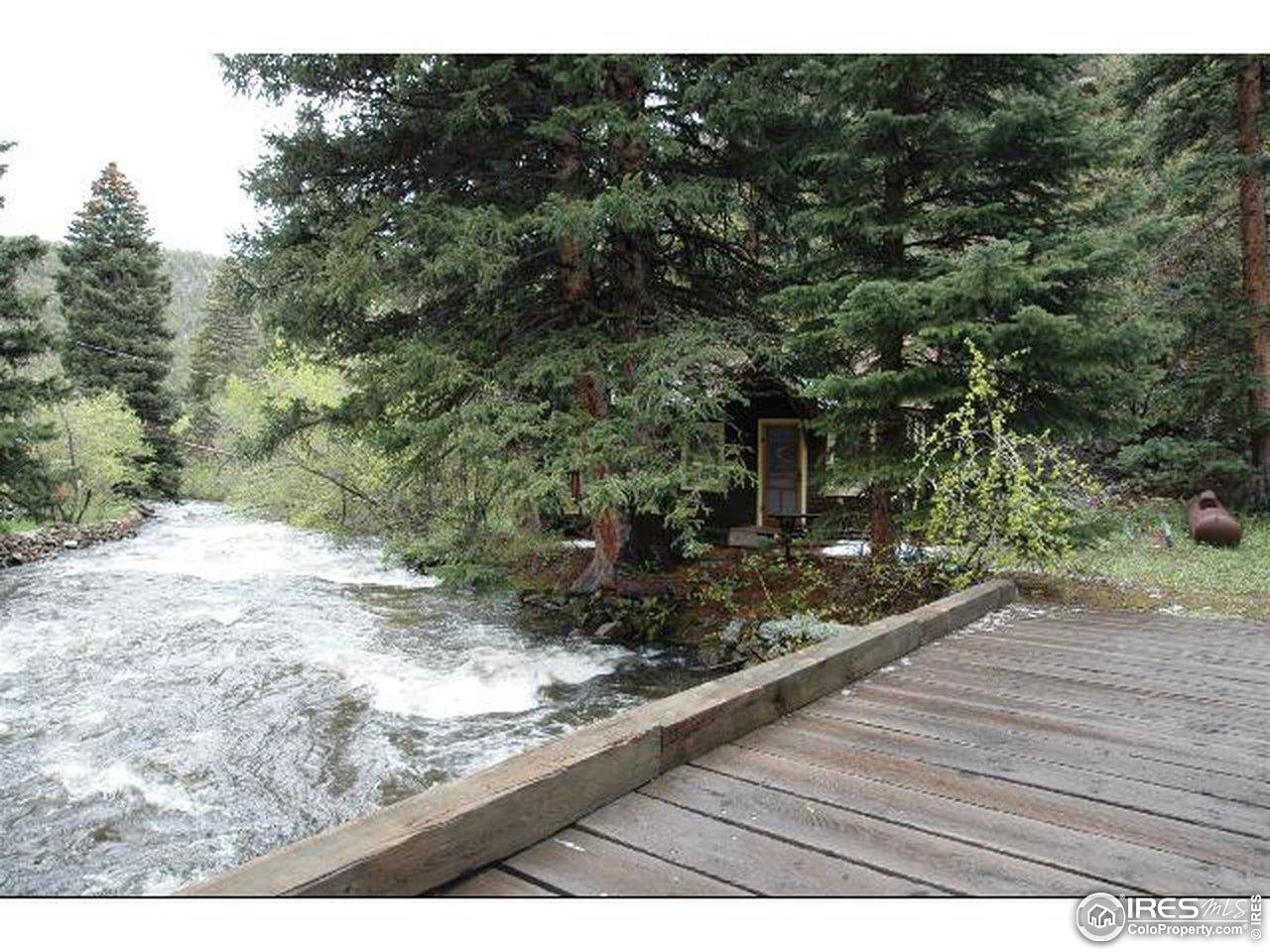 2203 Riverside Drive Lyons, CO 80540 - Photo 14 of 16 a view of a wooden deck with a bench