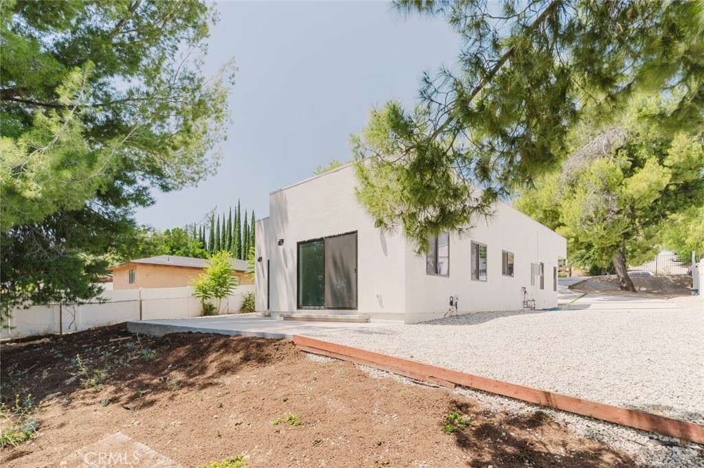 17846 Rinaldi Street Granada Hills, CA 91344 - Photo 26 of 34 a front view of a house with a yard and garage