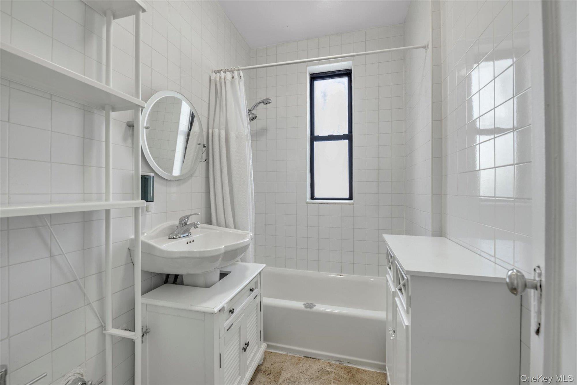 72-34 Austin Street, Unit F10 Queens, NY 11375 - Photo 13 of 15 Full bath with shower / tub combo with curtain, tile walls, and vanity