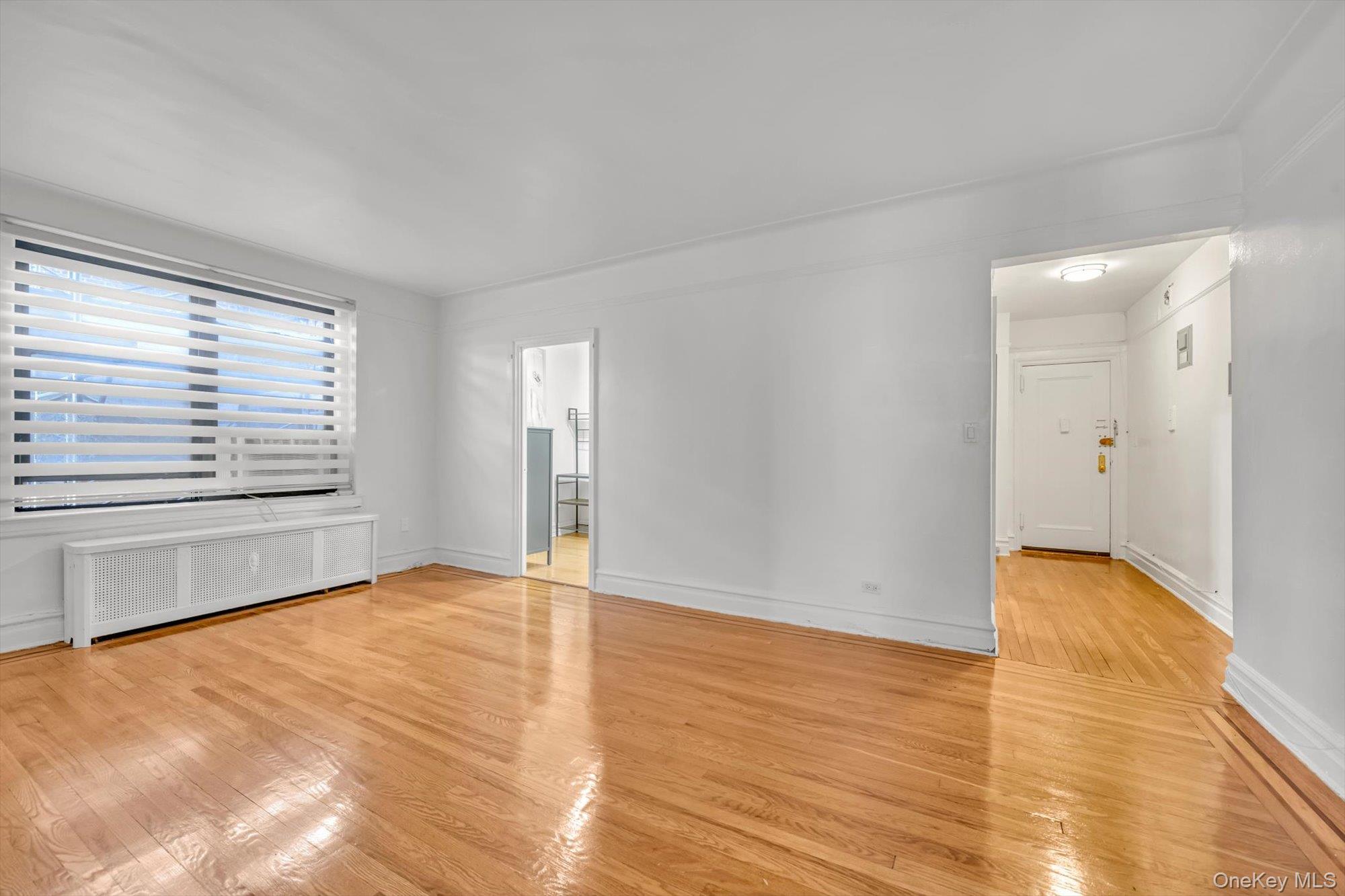 72-34 Austin Street, Unit F10 Queens, NY 11375 - Photo 5 of 15 Spare room featuring radiator and light wood finished floors