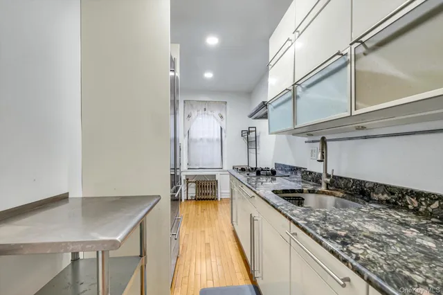 a view of hallway with wooden floor and cabinet