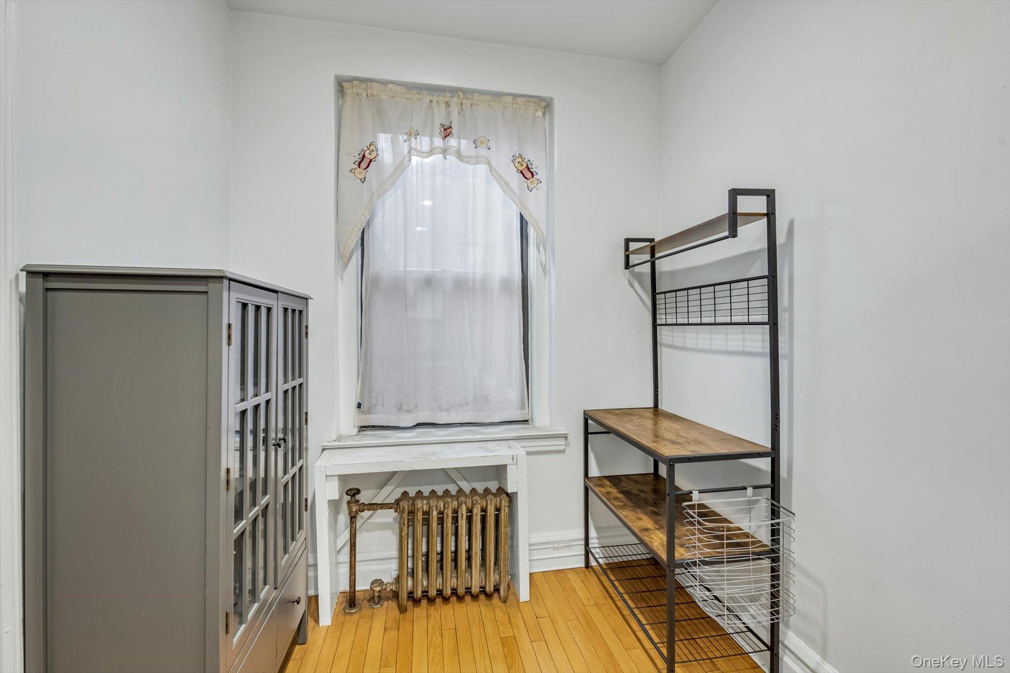 72-34 Austin Street, Unit F10 Queens, NY 11375 - Photo 9 of 15 Bedroom featuring light wood finished floors and radiator