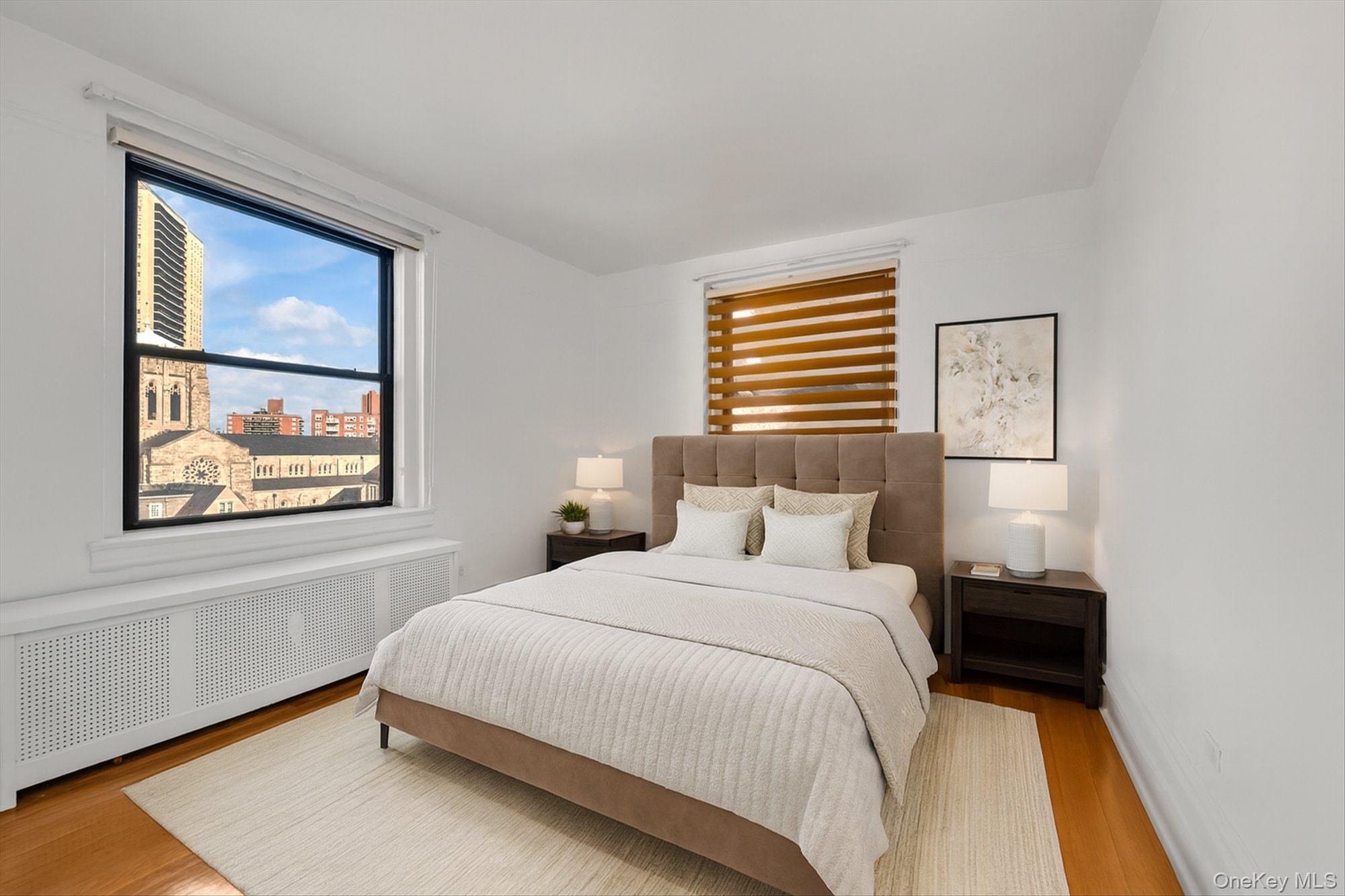 72-34 Austin Street, Unit F10 Queens, NY 11375 - Photo 10 of 15 Bedroom featuring wood finished floors, radiator, and a city view