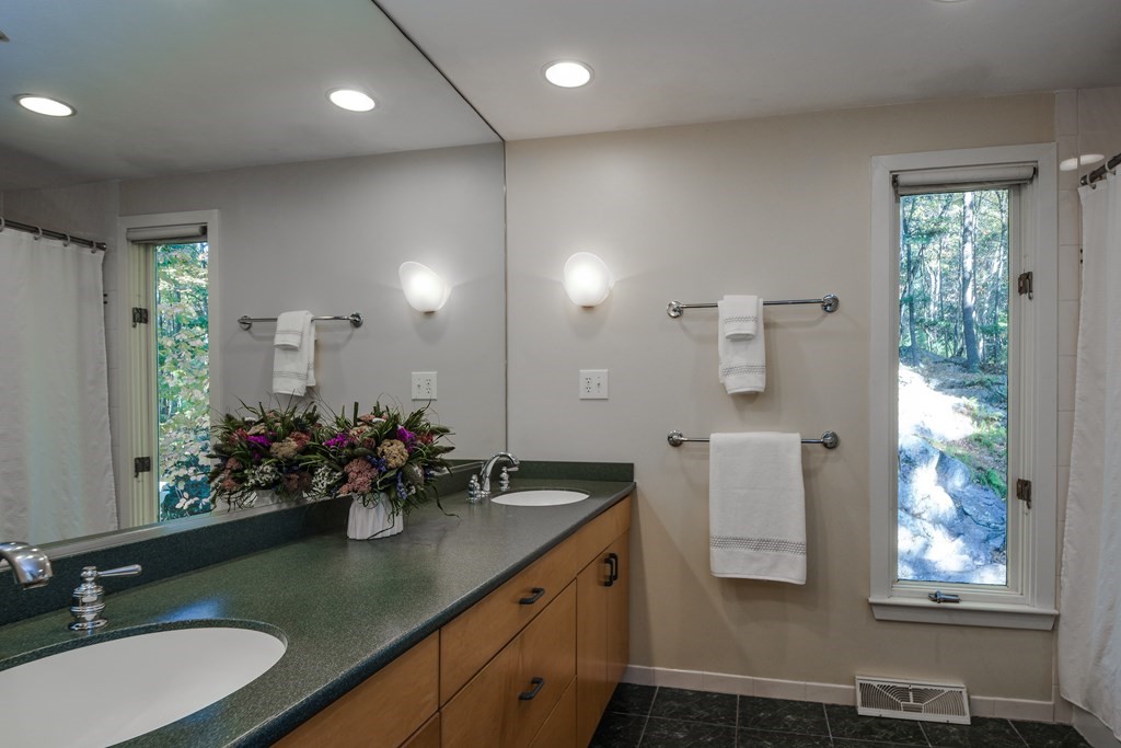 50 Old Orchard Road Sherborn, MA 01770 - Photo 20 of 26 a bathroom with a granite countertop sink a large mirror and a shower