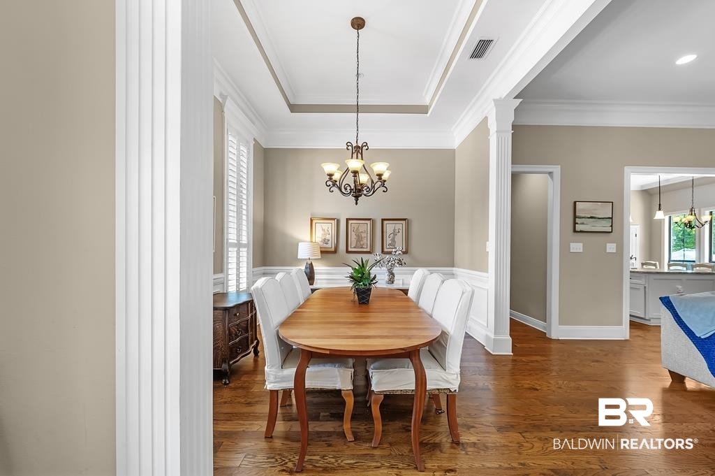 30014 Dolive Ridge Daphne, AL 36527 - Photo 16 of 57 Dining room featuring a chandelier, dark wood-type flooring, crown molding, and a raised ceiling