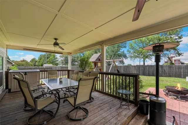 a view of a backyard with a slide trees and wooden fence