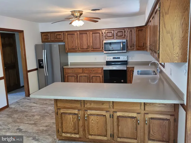 a kitchen with stainless steel appliances granite countertop a refrigerator a stove top oven a sink and dishwasher
