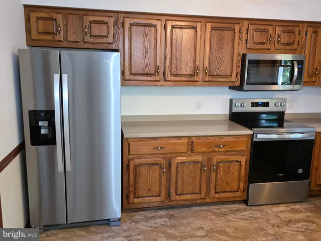 a kitchen with stainless steel appliances granite countertop a refrigerator and microwave