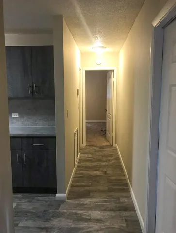 a view of a hallway with wooden floor and staircase